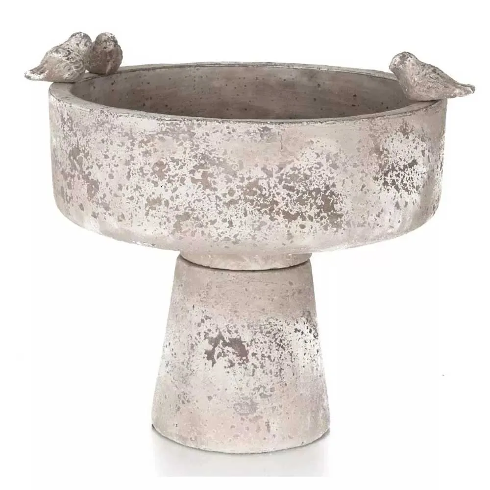A charming concrete bird bath with three concrete birds on the edge